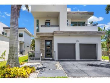 Modern two-story home boasts a two-car garage and contemporary design with a welcoming entrance at 2246 Fiesta Dr, Sarasota, FL 34231