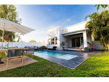Inviting backyard pool with a dining and sitting area is perfect for relaxation and entertaining at 2246 Fiesta Dr, Sarasota, FL 34231