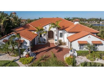 Elegant home featuring a red tile roof, arched entryway, mature landscaping, and brick driveway at 751 34Th Ne Ave, St Petersburg, FL 33704