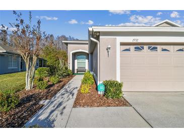Charming home exterior with a well-manicured lawn and an attached garage at 2932 Tanglewylde Dr, Land O Lakes, FL 34638