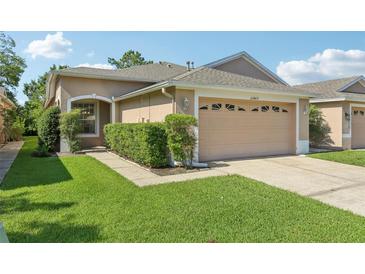 Charming single-story home featuring a well-manicured lawn and a two-car garage at 31447 Shaker Cir, Wesley Chapel, FL 33543