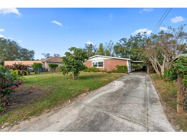 Charming brick home with a long driveway and a well-manicured lawn, perfect for suburban living at 7918 Croton Ave, Tampa, FL 33619