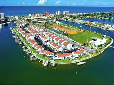 Expansive aerial view of waterfront homes with lush greenery and ocean views at 169 Medallion Blvd # E, Madeira Beach, FL 33708