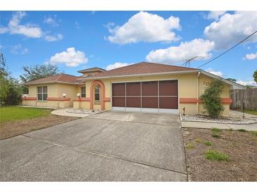 Charming single Gathering home featuring a two-car garage, peach accents and a well maintained front yard at 10412 Ireland St, Spring Hill, FL 34608