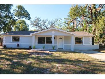 Charming single-story home featuring a well-maintained front yard with mature trees and a freshly painted exterior at 7160 Lenape Cir, New Port Richey, FL 34653