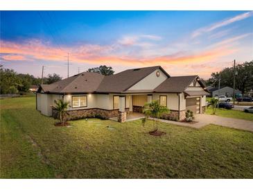 Beautiful single-story home with manicured lawn, stylish accents, and attached two car garage at 2972 Lake Saxon Dr, Land O Lakes, FL 34639