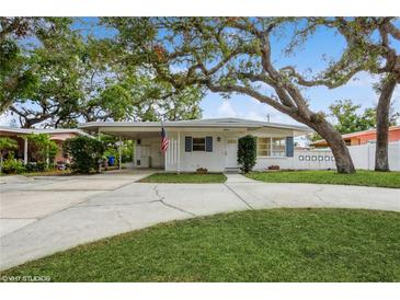 Charming single-story home with a well-maintained lawn and mature trees providing ample shade at 51 Lexington Dr, Dunedin, FL 34698