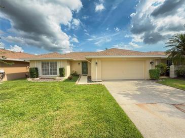 Charming single-story home with a well-manicured lawn and a two-car garage, with lush landscaping at 2267 Heron Cir, Clearwater, FL 33762