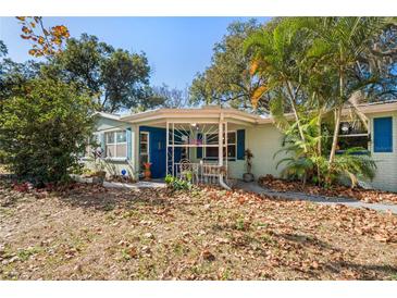 Charming one-story home with blue shutters and inviting front porch, nestled among lush greenery at 8537 Cameo Dr, New Port Richey, FL 34654