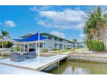 Charming waterfront condos featuring a dock with seating area and covered outdoor dining at 300 Venetian Dr # 7, Clearwater, FL 33755