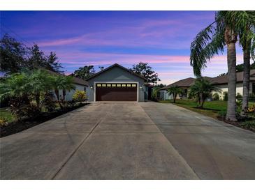 Charming single-story home with a long driveway, lush landscaping, and an attached two car garage at 3369 Houle Ave, Sarasota, FL 34232