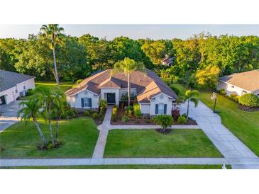 Charming single-story home featuring a manicured lawn, mature trees, and a long driveway leading to a basketball hoop at 6020 Kestrel Point Ave, Lithia, FL 33547