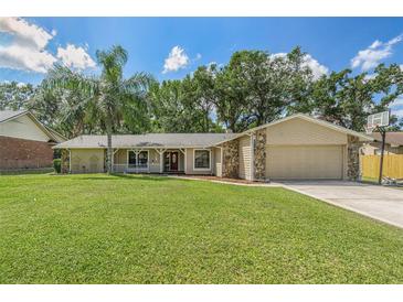 Charming single-story home with a well-maintained lawn, stone accents, and a welcoming front porch at 823 Scenic Heights Dr, Brandon, FL 33511