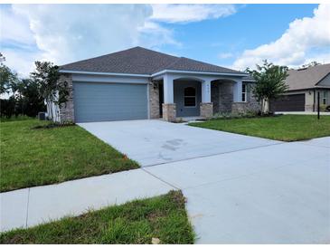 Charming single-story home featuring a brick facade, well-manicured lawn, and a two-car garage at 422 Shannon Estates Ct, Plant City, FL 33563