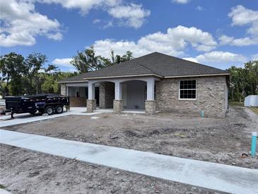Charming single-story home featuring brick exterior, covered porch, and unfinished landscaping at 422 Shannon Estates Ct, Plant City, FL 33563