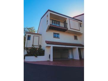 Stunning townhouse featuring stucco walls, red tile roofing, private balcony, and attached garage at 240 Windward Psge # 1101, Clearwater Beach, FL 33767