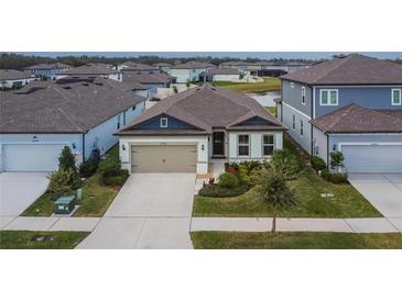 Charming single-story home featuring a two-car garage and a well-manicured front yard at 12940 Brookside Moss Dr, Riverview, FL 33579
