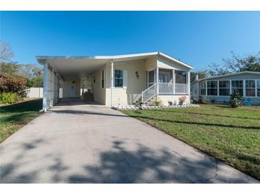 Charming single Gathering home featuring a carport, screened in porch, and manicured lawn at 5142 Serene Sq, New Port Richey, FL 34653