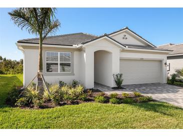 Charming single-story home with a well-manicured lawn and lush landscaping at 12193 Meditation Trl, Venice, FL 34293