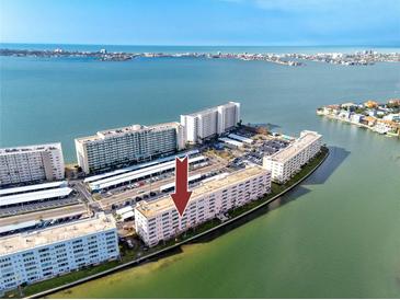 A captivating aerial view of a waterfront condominium complex surrounded by pristine turquoise waters at 6025 Shore S Blvd # 311, Gulfport, FL 33707