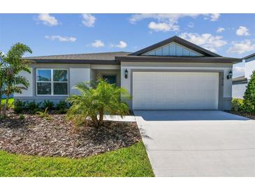 Charming single-story home featuring a well-manicured front yard and a two-car garage at 12815 Wanderlust Pl, Parrish, FL 34219