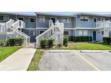 Exterior view of a two-story condo building with white stairs and green landscaping in front at 6033 34Th W St # 45, Bradenton, FL 34210