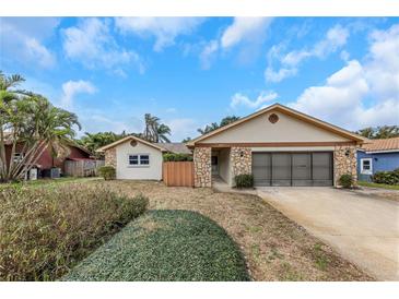 Charming single-story home with stone accents, a two-car garage, mature landscaping, and inviting curb appeal at 435 Meadowlark Ln, Palm Harbor, FL 34683