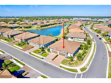 An aerial view of a well-maintained home by a scenic pond with lush landscaping at 5426 Rushmere Ct, Palmetto, FL 34221