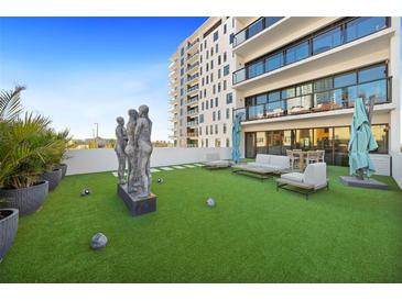 Expansive rooftop terrace featuring artificial turf, lounge seating, and modern sculptures with views of the building at 199 Dali Blvd # 407, St Petersburg, FL 33701
