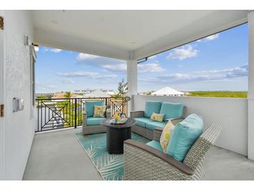 Inviting balcony featuring stylish outdoor seating, a cozy rug, and a charming coffee table, perfect for relaxation at 3027 Bermuda Sloop Cir, Ruskin, FL 33570