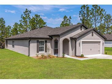 Charming single-story home featuring a two-car garage, arched entryway, and neatly manicured lawn at 7220 Swartburg Rd, North Port, FL 34291