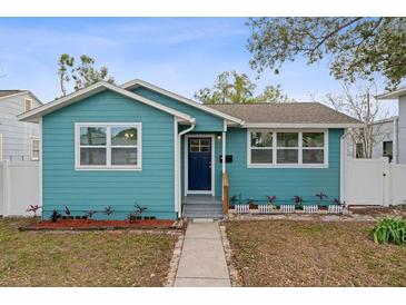 Charming teal bungalow featuring a well-kept lawn and an inviting front porch at 3030 5Th N Ave, St Petersburg, FL 33713