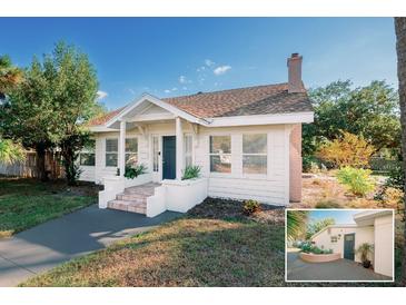 Charming home featuring a brick chimney, a landscaped yard, and a front door at 4056 18Th S Ave, St Petersburg, FL 33711