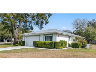 Charming home exterior featuring well-maintained landscaping and attached two-car garage at 13000 Club Dr, Hudson, FL 34667