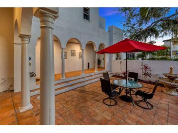 Charming patio area with brick flooring, outdoor seating, and white pillars, perfect for entertaining at 4845 W Sunset Blvd, Tampa, FL 33629