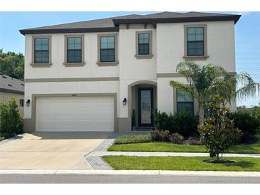 Charming two-story home with a manicured lawn and a two-car garage at 14786 Horse Trot Rd, Lithia, FL 33547