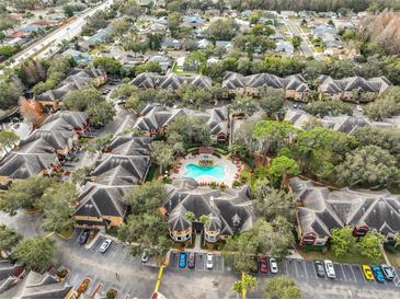 An aerial view of a community featuring a pool, mature landscaping, and ample parking at 2160 Chianti Pl # 11-0117, Palm Harbor, FL 34683