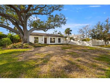 Charming home with a well-manicured lawn and a beautiful, mature tree offering ample shade at 431 Rafael Ne Blvd, St Petersburg, FL 33704