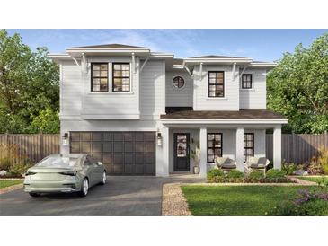 Charming two-story home boasts white siding, a modern garage door, and a cozy covered front porch at 1009 W Ohio Ave, Tampa, FL 33603