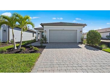Charming single-Gathering home with a well-manicured lawn, paved driveway, and attached two-car garage at 1975 Pepper Grass Dr, North Port, FL 34289