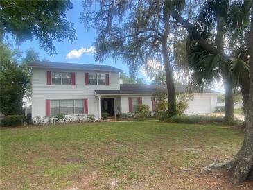 Charming two-story home with red shutters, a well-maintained lawn and beautiful, mature shade trees at 6919 Greenhill Pl, Tampa, FL 33617