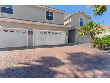 Inviting home with brick driveway, three-car garage, and well-maintained landscaping at 1264 Riserva Ln, Palm Harbor, FL 34683