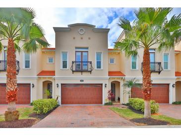 Charming two-story townhome featuring a private garage, balcony, and lush landscaping at 3222 W Empedrado St, Tampa, FL 33629