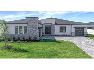 Beautiful single Gathering home featuring a modern exterior with brick driveway, lawn and minimalist landscaping at 8347 Golden Beach Ct, Parrish, FL 34219