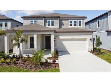 Two-story home featuring a two-car garage, neutral color scheme, and a manicured front yard at 12660 Glenn Creek Dr, Riverview, FL 33569