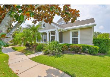 Charming single-story home featuring a covered porch, well-manicured lawn, and lush landscaping at 217 Oceania Ct, Apollo Beach, FL 33572
