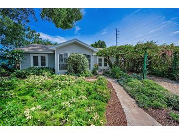 Charming home featuring lush, mature landscaping and a welcoming stone pathway to the front door at 546 Orangewood Dr, Dunedin, FL 34698