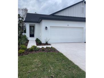 Charming home with a modern design and well-maintained landscaping around the front entrance and a two-car garage at 3739 Nandina Cir, Sun City Center, FL 33573