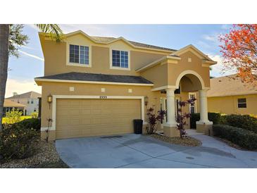 Charming home boasting an attached garage, manicured shrubs, and an arched entryway at 8999 Founders Cir, Palmetto, FL 34221
