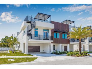 Modern three-story home featuring a spiral staircase and rooftop deck with sleek, contemporary design elements at 8631 5Th Street North, St Petersburg, FL 33702